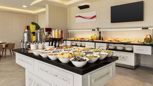 A buffet setup with various food items and a coffee station. - Ramada By Wyndham Cesme (Cesme)