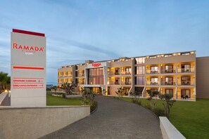 A modern hotel with a sign indicating "Ramada by Wyndham Çeşme" and directional arrows to "Otopark/Carpark" and "Giris Kapisi/Entrance". - Ramada By Wyndham Cesme (Cesme)