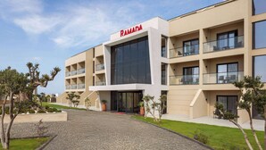 A modern building with a flat roof, large windows, and a sign reading 'RAMADA'. - Ramada By Wyndham Cesme (Cesme)