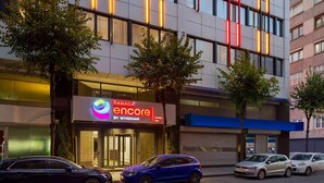 A modern building with a storefront named "Ramada Encore by Wyndham."