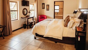 Une chambre avec un plafond en bois, un lit, un bureau, une chaise et une fenêtre.