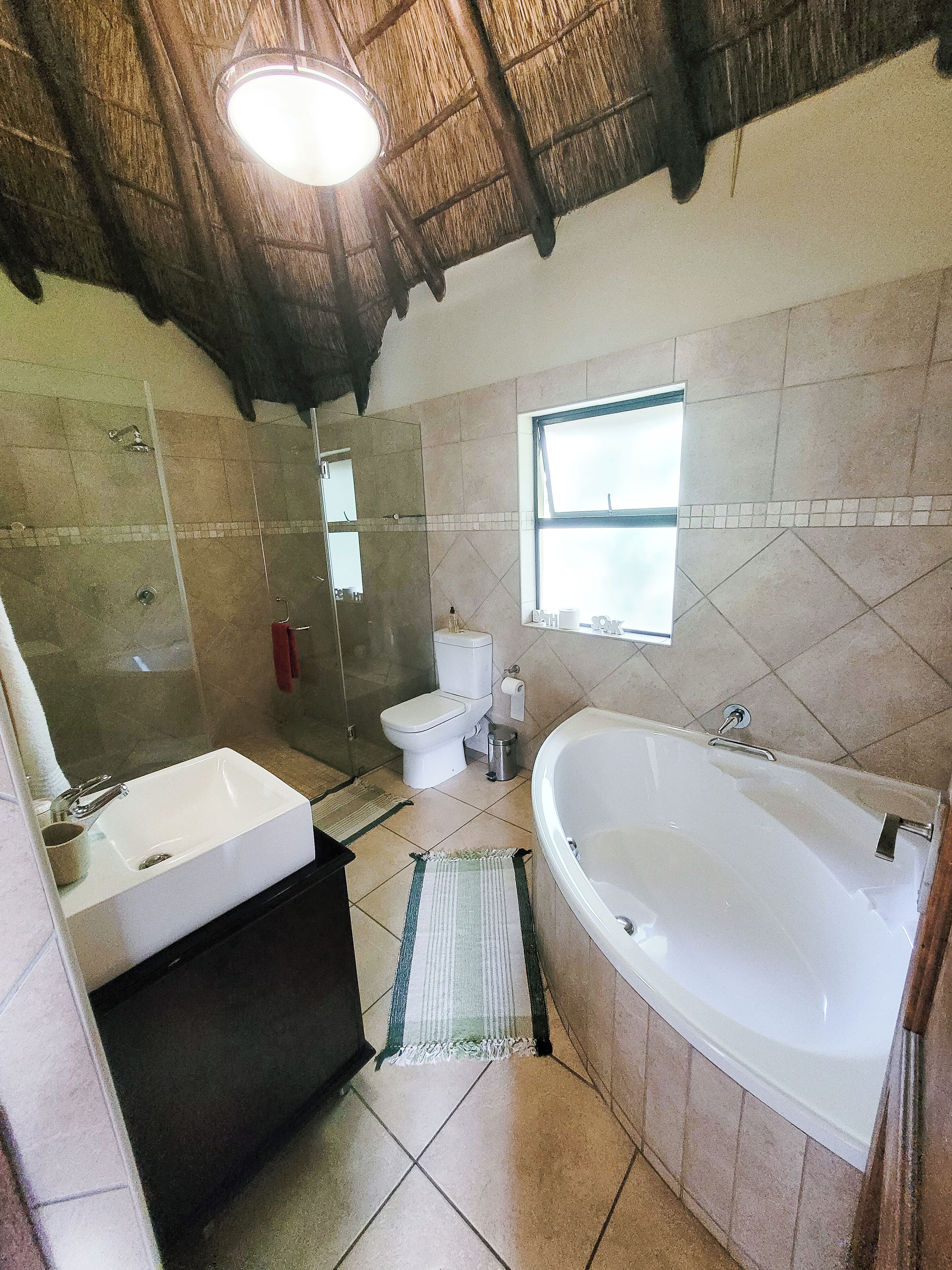 A bathroom with a bathtub, sink, toilet, and a shower area.