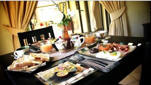 Une table de petit-déjeuner avec divers aliments, notamment des toasts, des œufs et une salade de fruits.