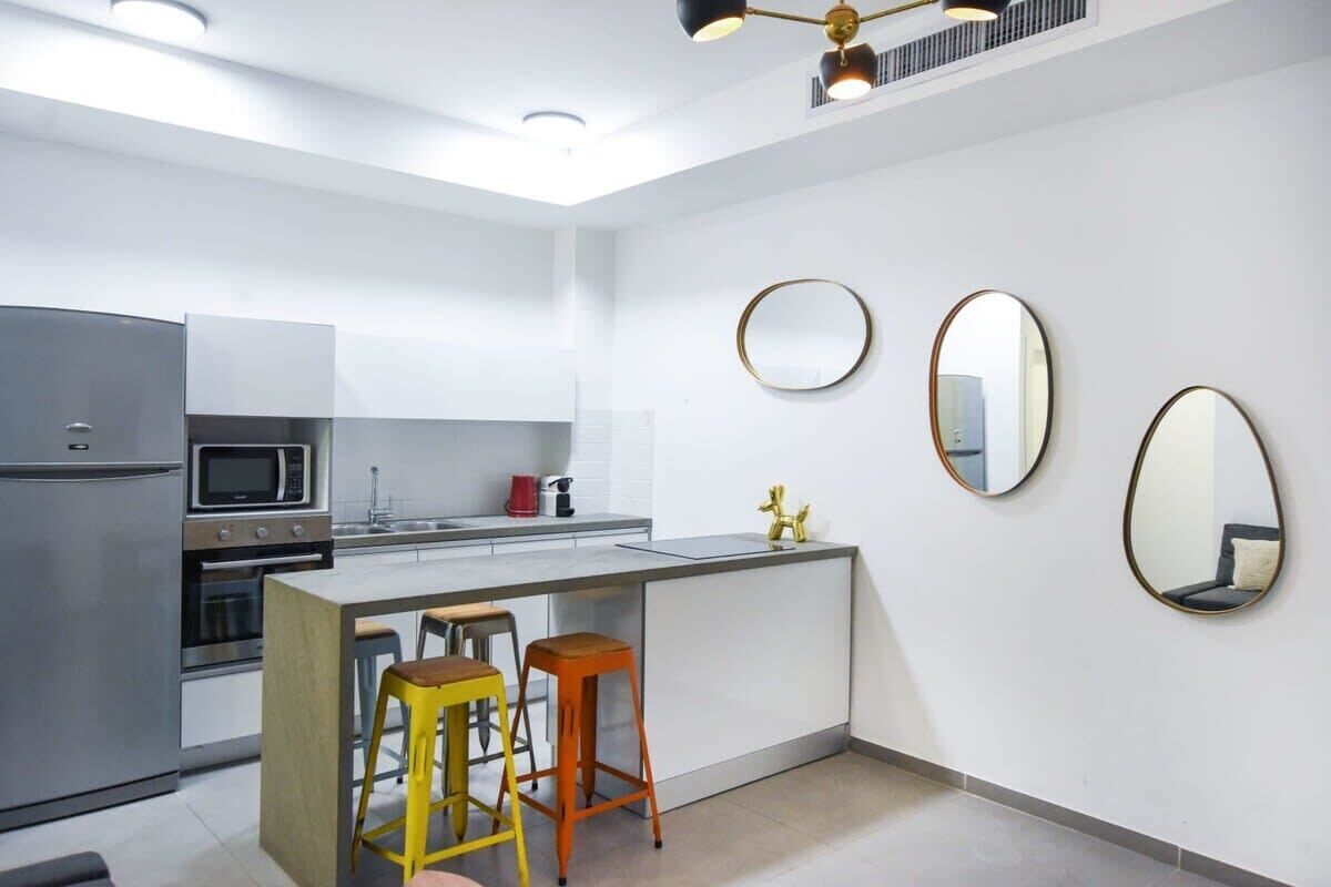 A modern kitchen with a central island, stainless steel appliances, and a minimalist design.
