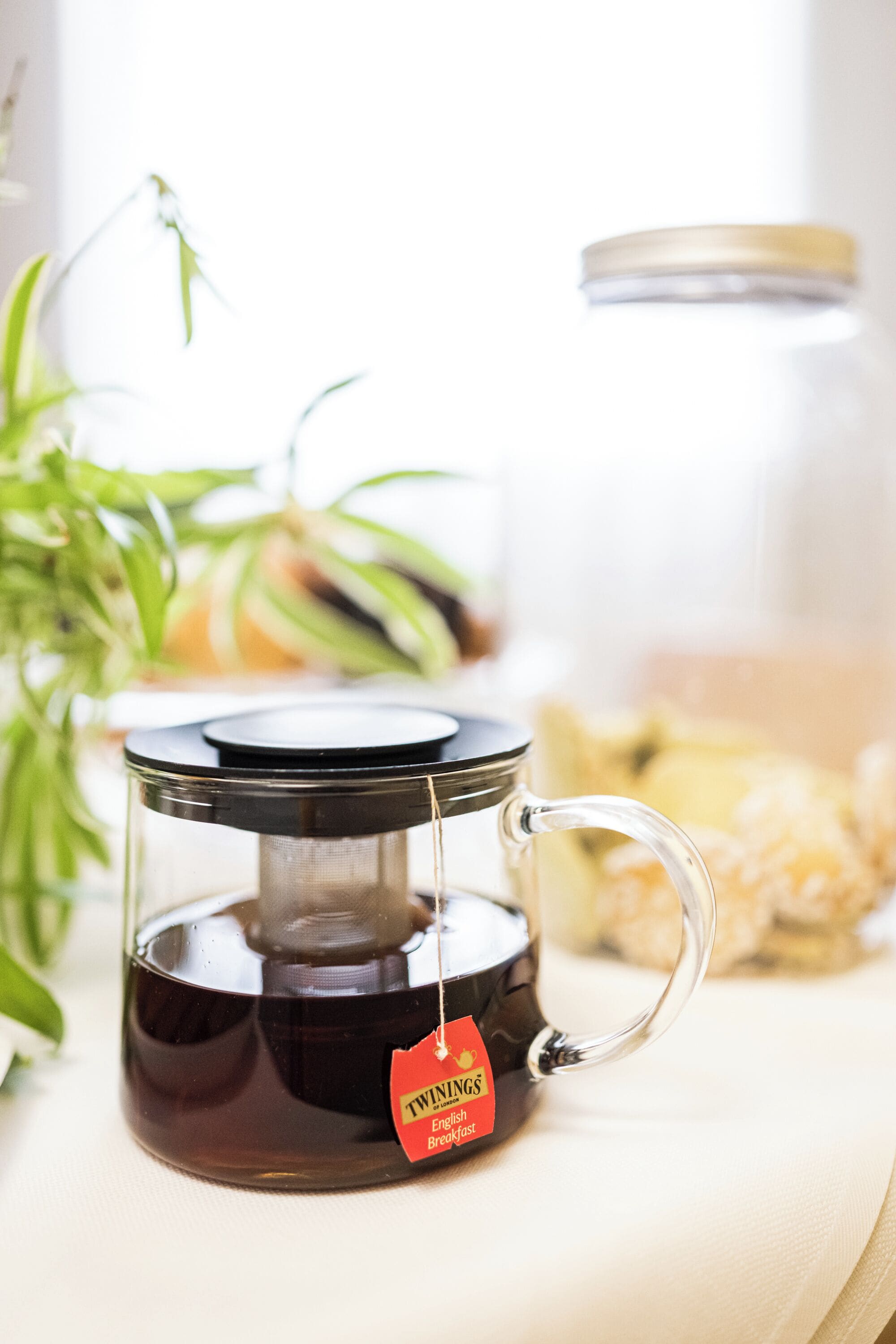 A glass coffee pot with a tea bag labeled "Twinings English Breakfast" on a table.