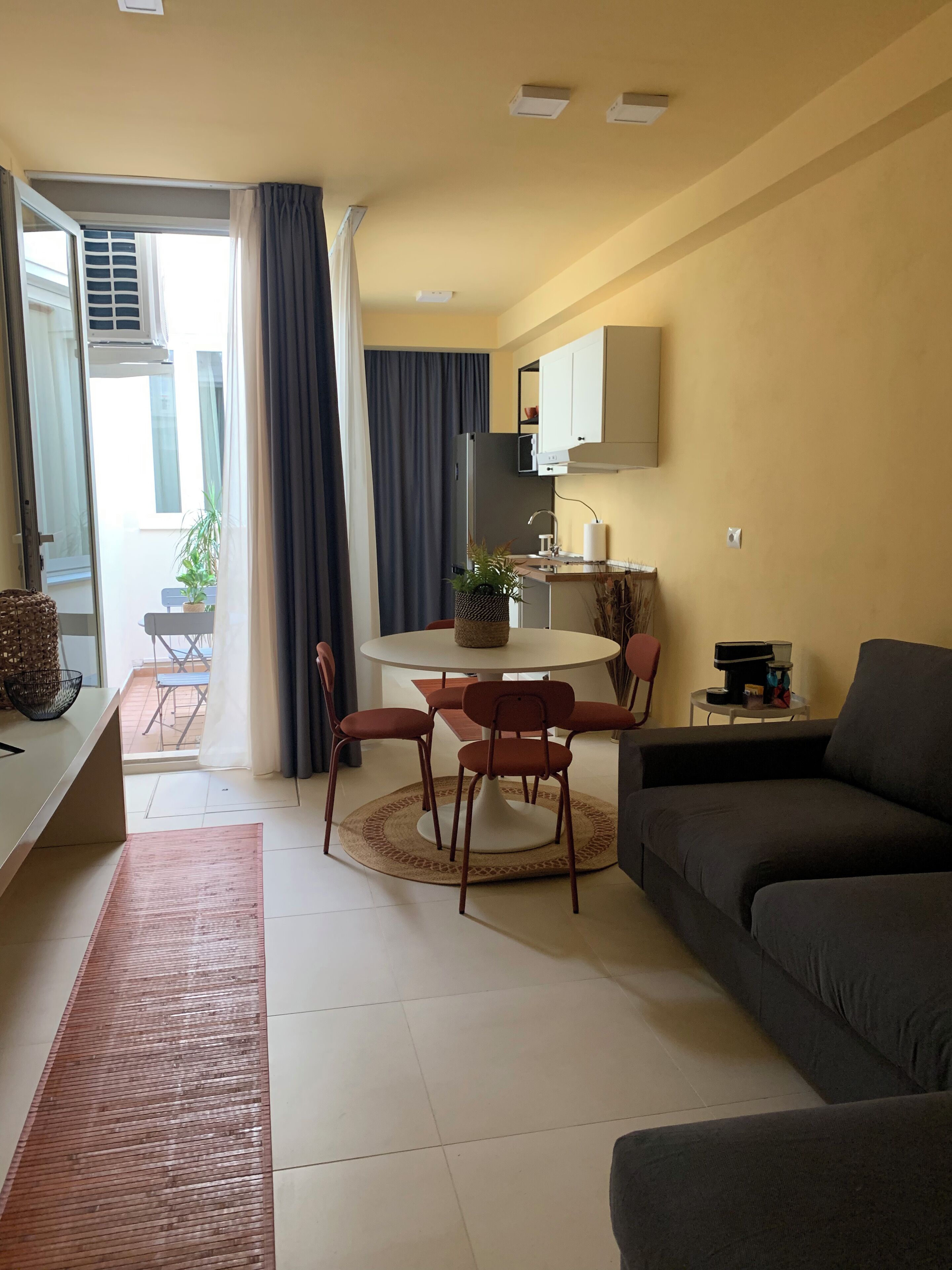 A compact living space with a dining area, kitchenette, and seating area.