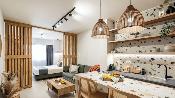 Um espaço de estar moderno e aberto, com cozinha, sala de jantar e um quarto.