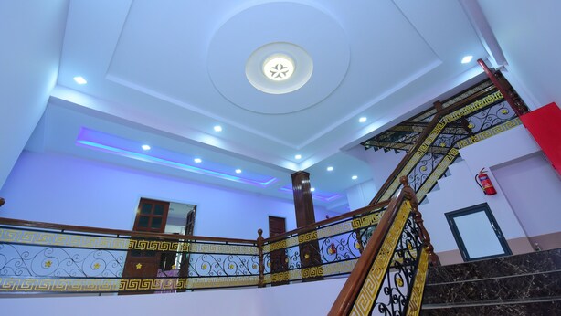 A modern interior with a spiral staircase, recessed lighting, and decorative ceiling panels. - Royal Palace Hotel - Magway (Magwe)