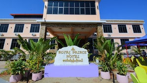 A hotel entrance with a sign reading "Royal Palace Hotel" and a modern building facade with large windows and a flat roof. - Royal Palace Hotel - Magway (Magwe)