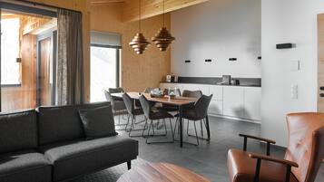 Relax in this inviting living area with a comfortable sofa and dining table, surrounded by chairs.