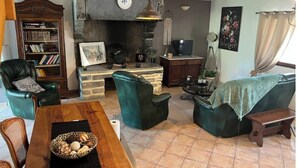 A cozy living room with a fireplace, a bookshelf, and comfortable seating.