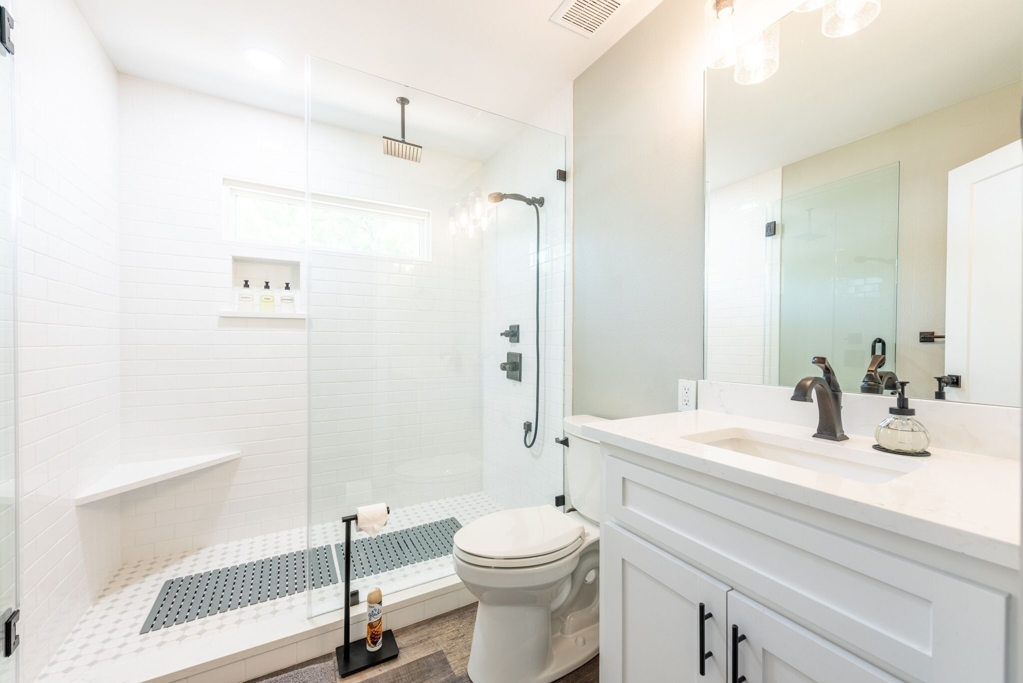Une salle de bain moderne équipée d’une douche, de toilettes et d’un meuble-lavabo.