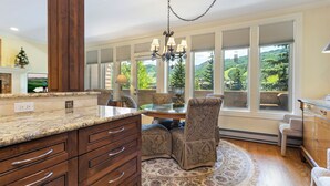 A spacious kitchen with a marble countertop, wooden cabinets, and a large window offering a scenic view. - Mtn Views a Short Walk to Lionshead Gondola, SV22A (Vail)