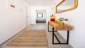 Un couloir avec une console en bois, un miroir et un tapis.