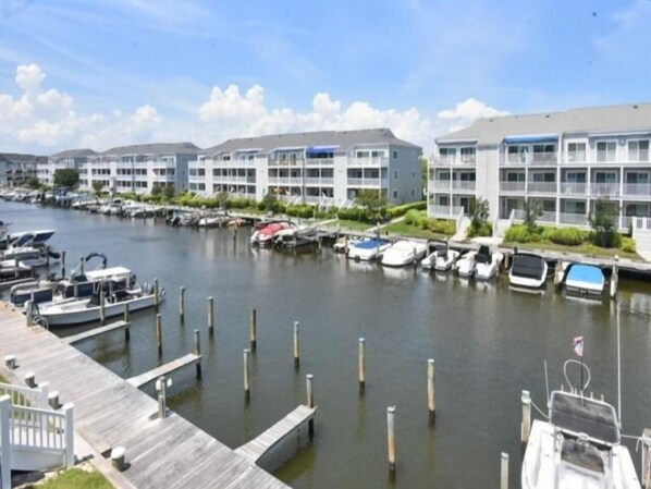 A marina with boats docked along a waterfront, connected by a wooden dock. - 2 Bedroom 2 Bath condo bayside with pool on canal (Ocean City)