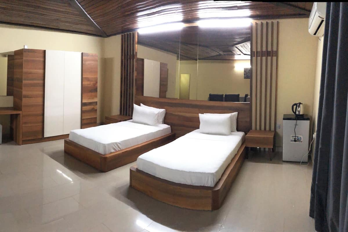Een hotelkamer met een bank, een klein tafeltje, een bed, een bureau en een televisie.