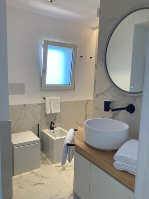 Een douche, een haardroger, een bidet, handdoeken