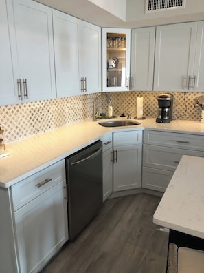 Enjoy cooking in this well-equipped kitchen with a dishwasher, coffee maker, and ample countertop space.