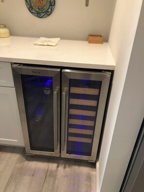 Compact kitchenette with a stainless steel refrigerator, microwave, and countertop for food preparation.