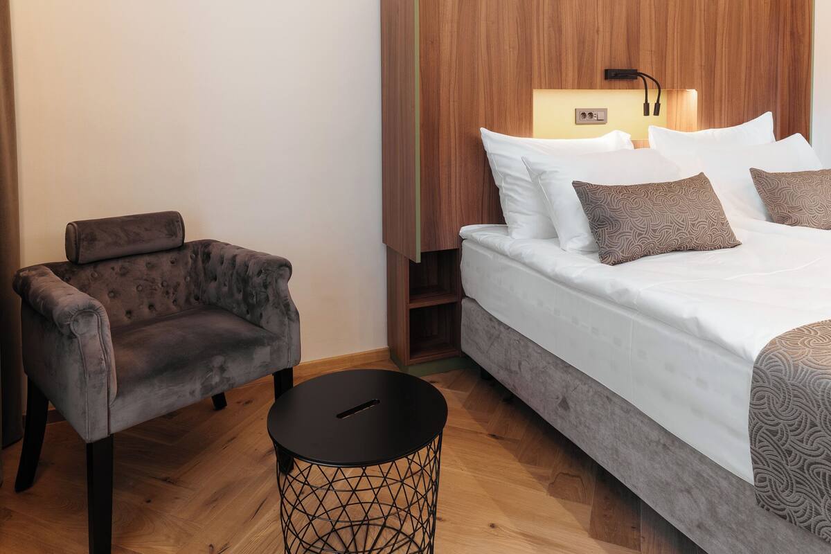 Ein Schlafzimmer mit Bett, Stuhl und kleinem Tisch.