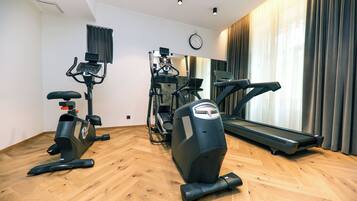 A gym with a treadmill, elliptical, and stationary bike.