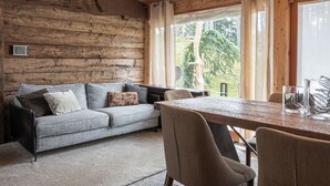 Un interior de madera con un sofá, sillas y una mesa de comedor.