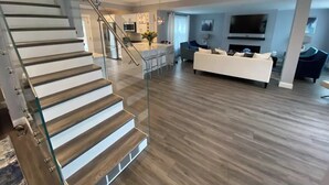 Un salon moderne avec un escalier, une cuisine et un coin repas.