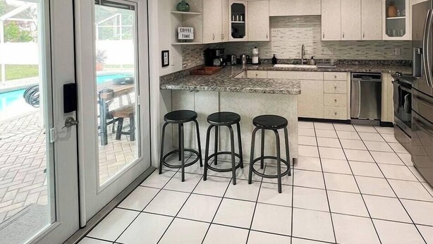 A modern kitchen with a central island, bar stools, and a sign that reads "Coffee Time".