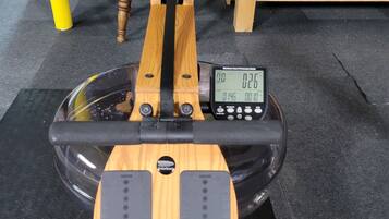 Uma bicicleta ergométrica com visor digital e pedais para os pés.