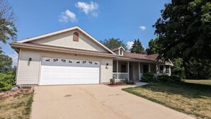 A single-story house with a garage, a covered porch, and a small front yard. - Private 3br, with SwimSpa, Gym, by Hwy 43, 67 & 50-Alpine Valley, Ice Age Trail- (Elkhorn)