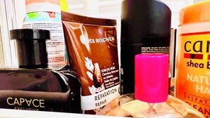 A basket containing various toiletries including a bottle of Caprice, a tube of Reparation, and a bottle of shampoo. - 156 Av. Pasteur b1 (Le Blanc-Mesnil)