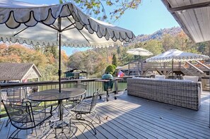 A deck with outdoor furniture, a grill, and a scenic view of trees and hills. - Lake Burton - Timpson Cove Luxury Cottage   (Clayton)
