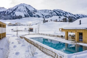Relax by the serene pool surrounded by snow-covered mountains and enjoy access to winter sports.