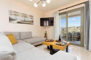 Ein modernes Wohnzimmer mit einem grauen Sofa, einem Holztisch und einem Gemälde an der Wand.