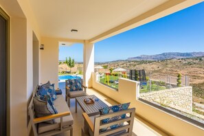Uma varanda com vista para uma piscina e montanhas.