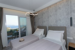 Une chambre d’hôtel avec deux lits, un balcon avec vue et un luminaire moderne.