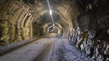 A tunnel with brick walls and a gravel path.