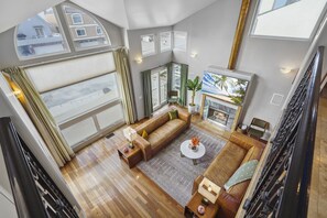 A spacious living room with a large window, a fireplace, and a cozy seating area.