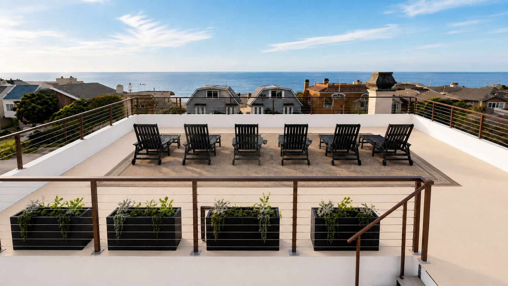 A rooftop terrace with outdoor seating and planters.
