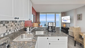 A kitchen with a granite countertop, stainless steel sink, and a coffee maker. - Amazing Oceanview Condo on the 17th Fl- 2 Balconies (Myrtle Beach)