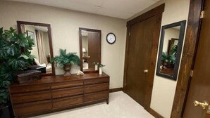 A room with a wooden dresser, two mirrors, a clock, and a door. - The Treehouse
 (Dayton)