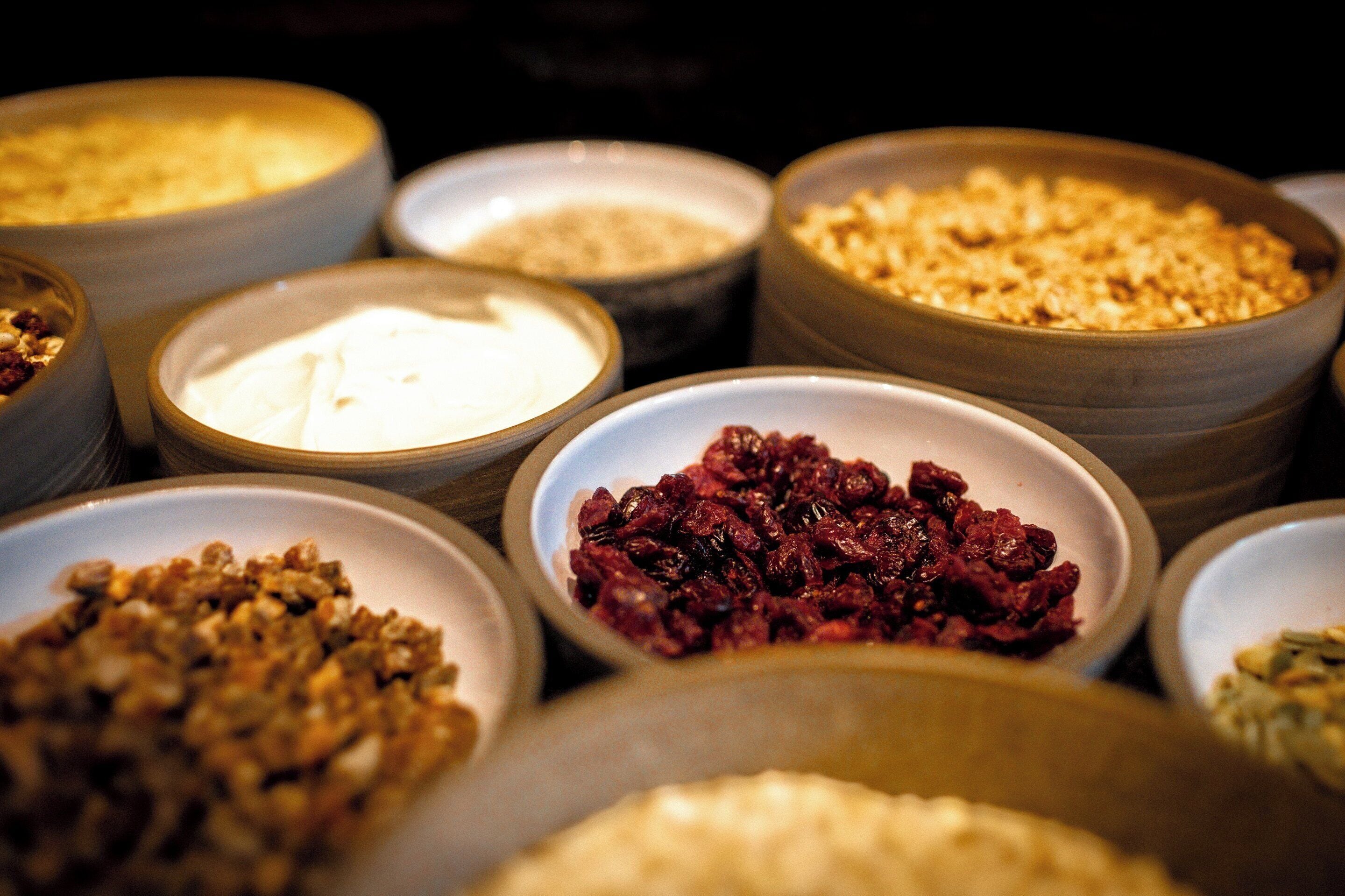 Diverse pietanze in ciotole, tra cui yogurt, granola e frutta secca.