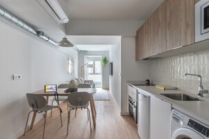 Una cucina moderna con lavastoviglie, lavello e mobili in legno.