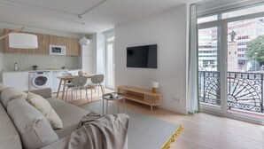 A modern apartment with a living area, kitchenette, and a balcony with a view of the city. - B48 Bilbao Abando (Bilbao)
