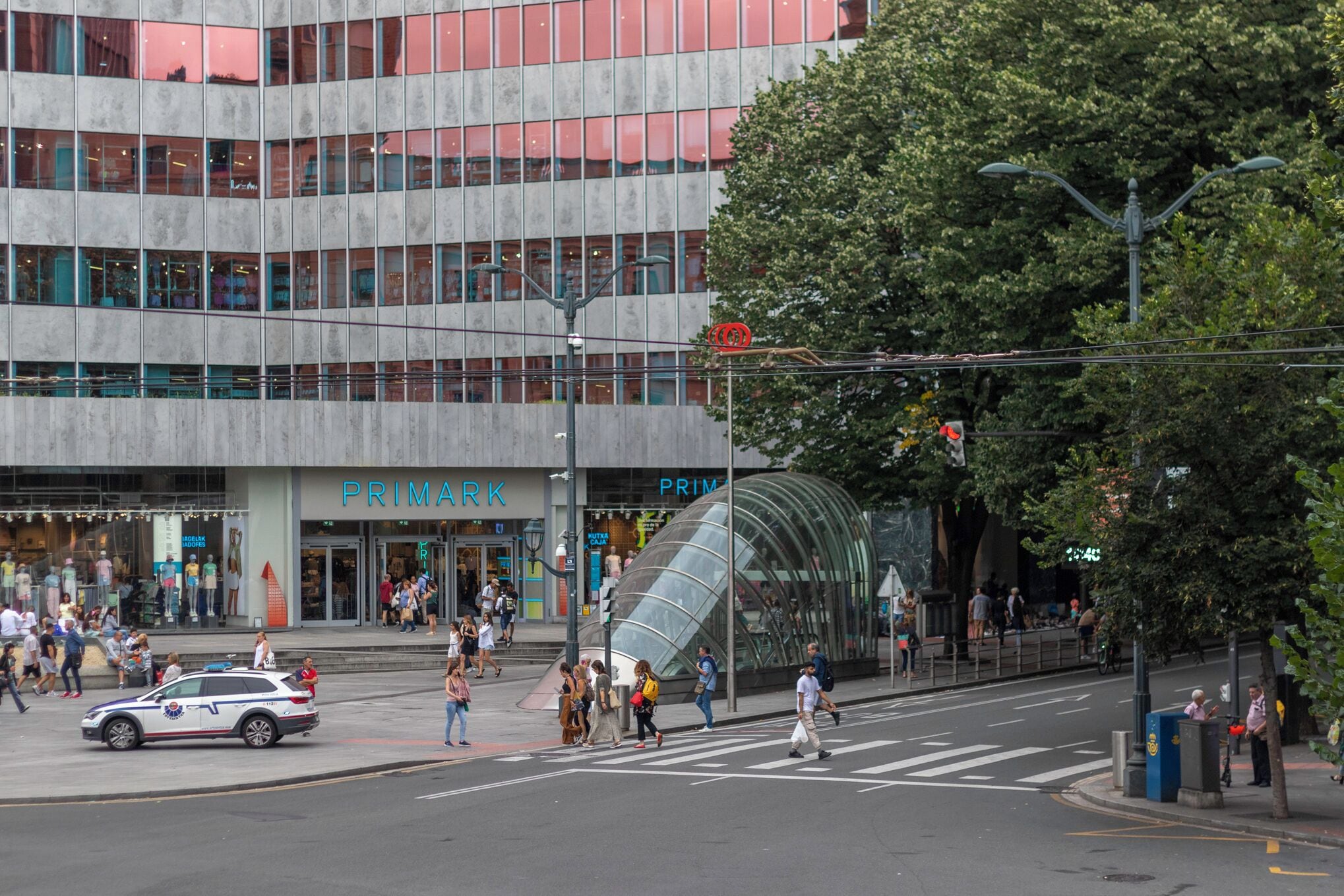 Un edificio moderno con fachada de vidrio y una entrada visible con el rótulo 