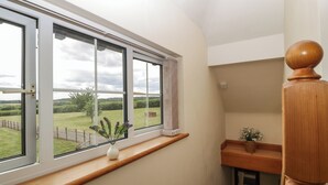 Een kamer met een groot raam dat uitkijkt op een grasveld.