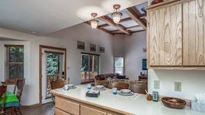 A spacious kitchen with wooden cabinets, a large island, and a dining area with chairs and a table. - Woodlands Way Chalet- A cozy get-away in Cloudcroft NM.
 (Cloudcroft)