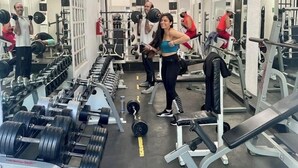 Une salle de sport équipée de divers appareils de musculation, de miroirs et de machines d’exercice.