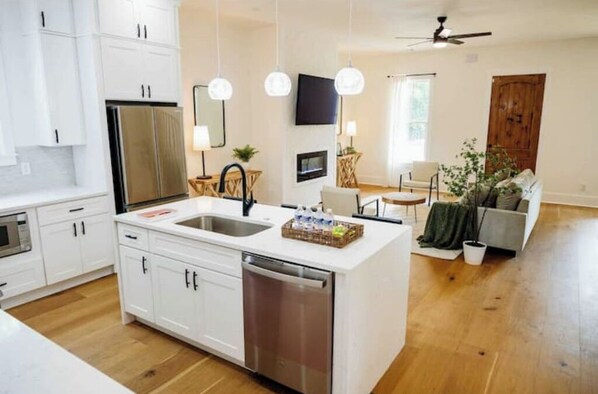 Enjoy cooking in this well-equipped kitchen with a central island, sink, and stainless steel appliances.