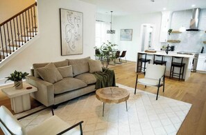 Relax in this stylish living space with a sofa, armchair, and dining area.